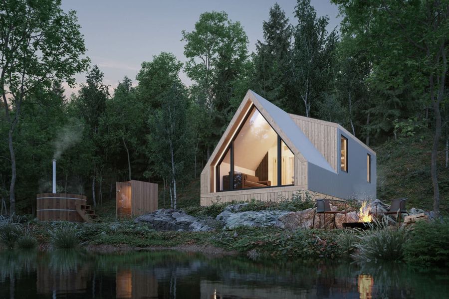 Classic A-frame park model tiny home by Zook Cabins with a cedar wood exterior beside a lake