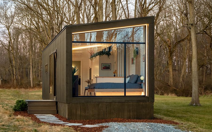 The Luna modern park model tiny home by Zook Cabins with floor-to-ceiling glass at golden hour